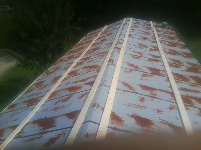 Rusted metal roof panels with new wood purlins before replacement — Storm Damage Roof Repair in Watford City by Roofing Brothers